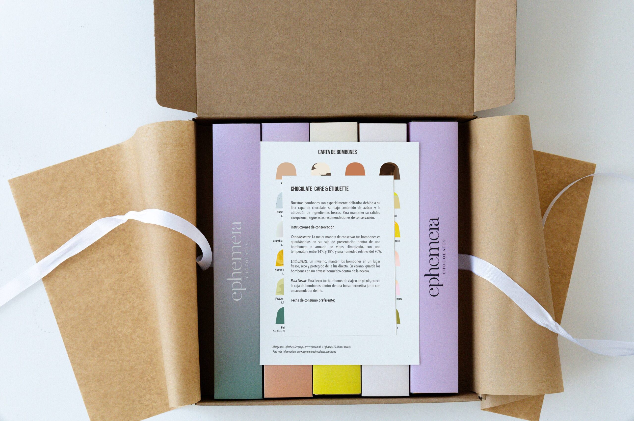 Packaging de chocolates Ephemera presentado en caja kraft con folleto informativo y envoltorio de seda.