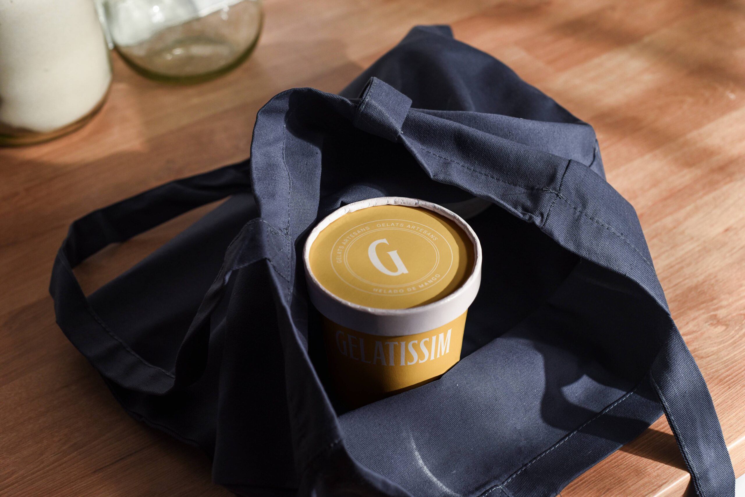 Packaging de helado Gelatissim con envase premium sobre bolsa de tela oscura
