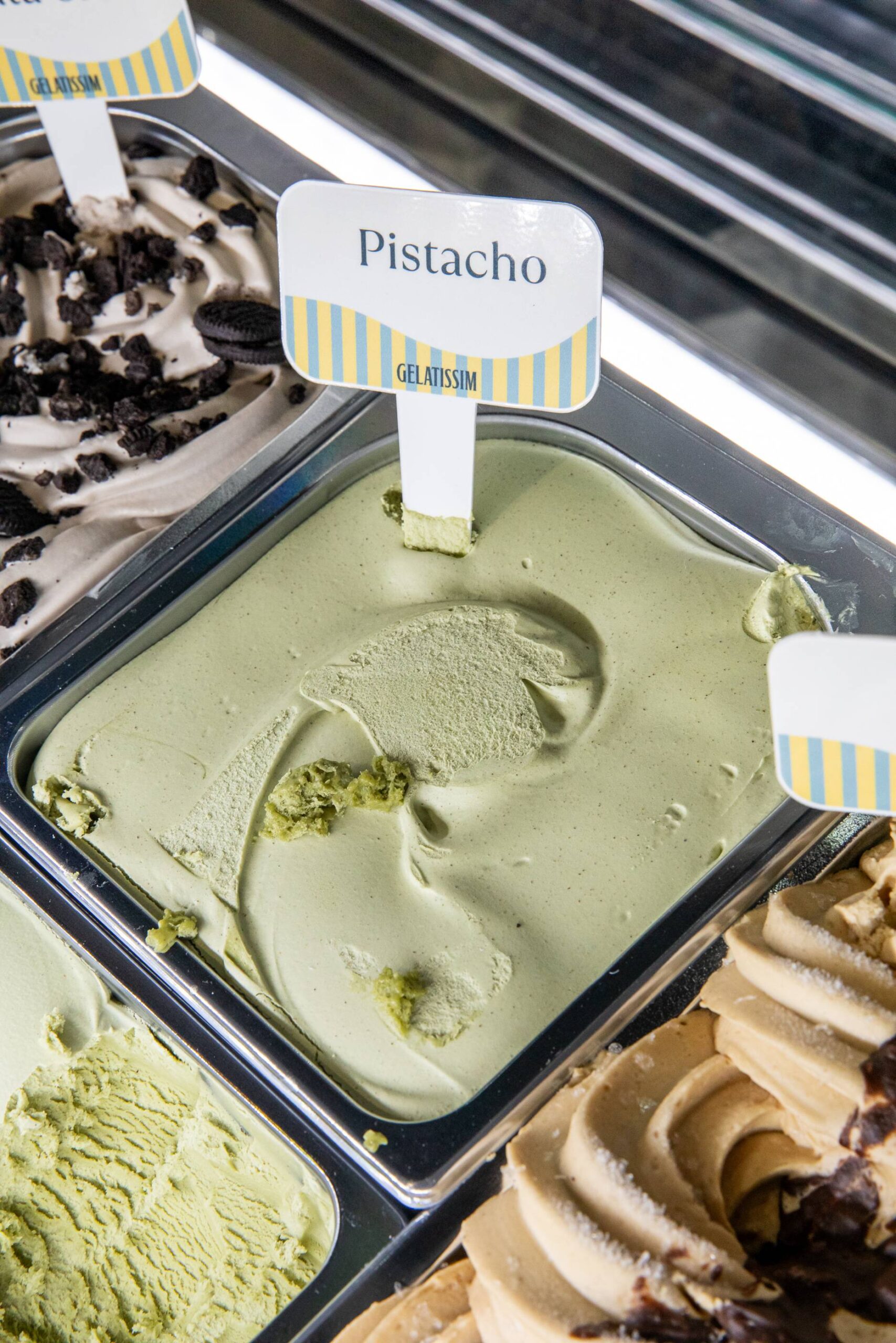 Helado artesanal de pistacho Gelatissim en vitrina de heladería.