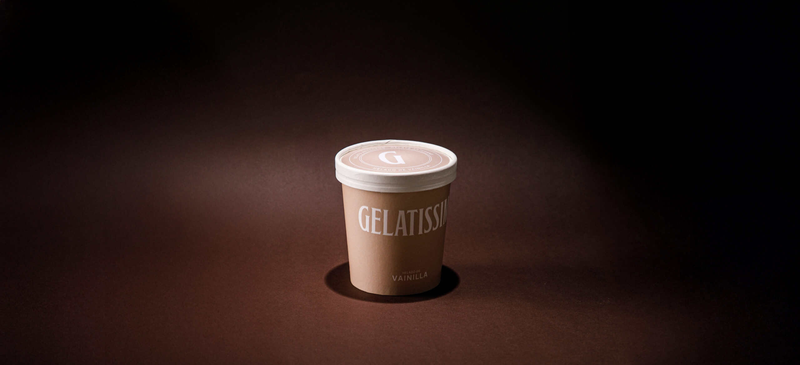 Tarrina de helado de vainilla Gelatissim sobre fondo oscuro.