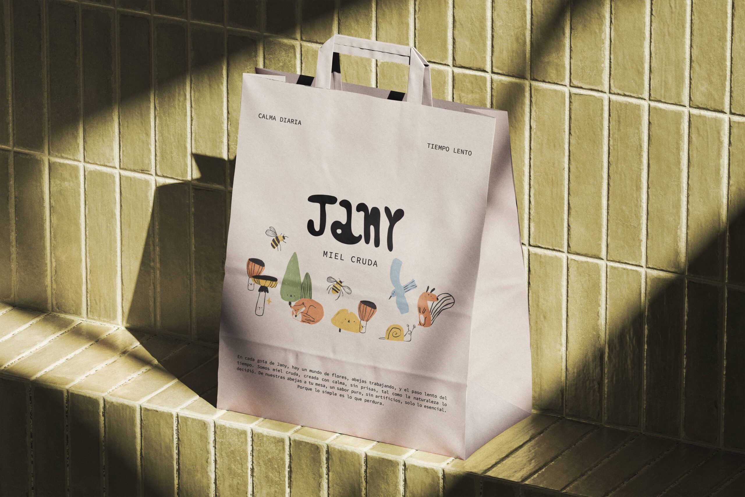 Bolsa de papel Jany con identidad visual artesanal iluminada por luz natural.