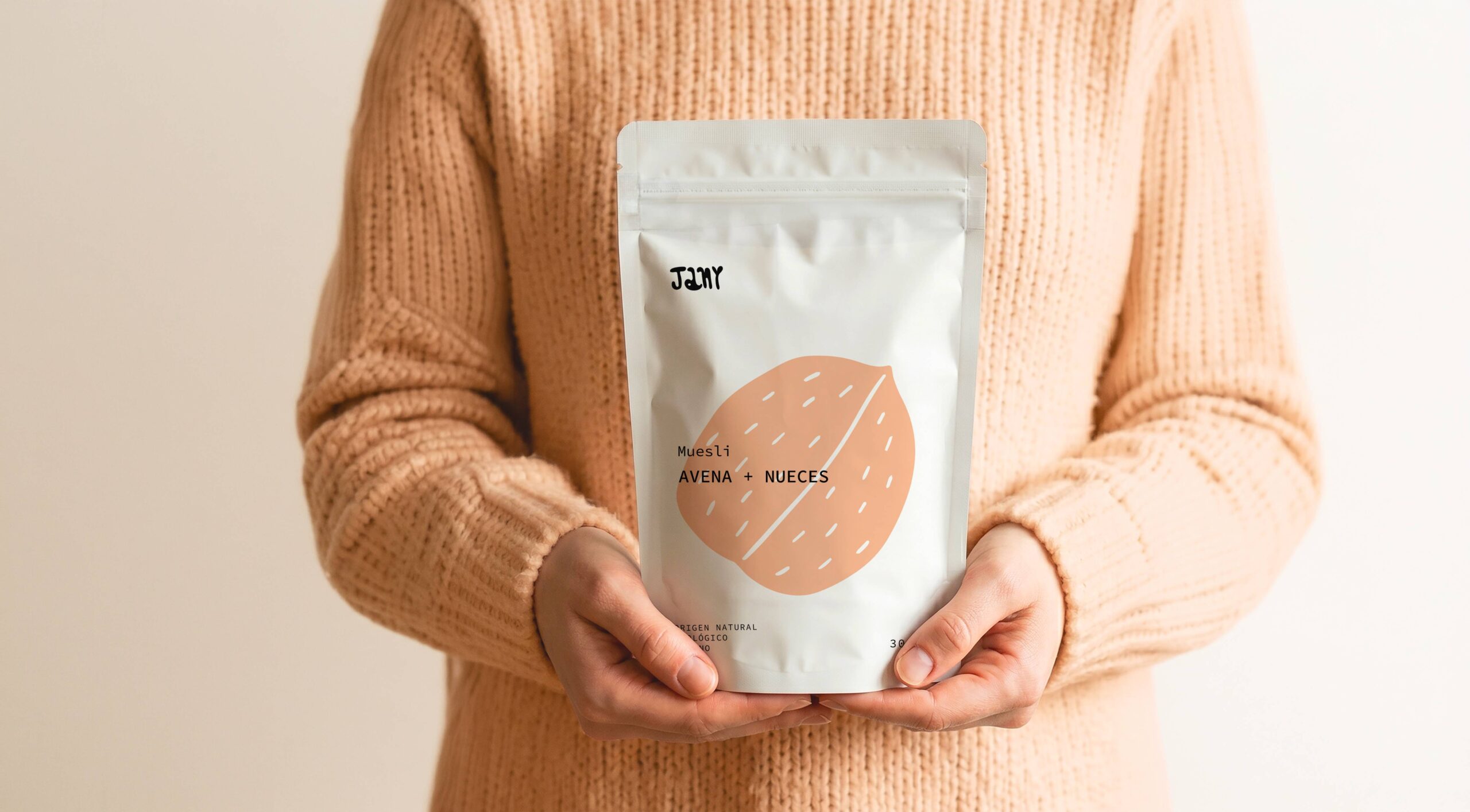 Persona sosteniendo bolsa de muesli Jany avena y nueces con diseño de packaging minimalista.
